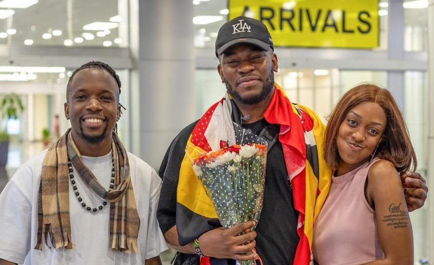 Nonso Amadi flanked by Watala and Lynda Ddane shortly after his arrival at Entebbe International Airport